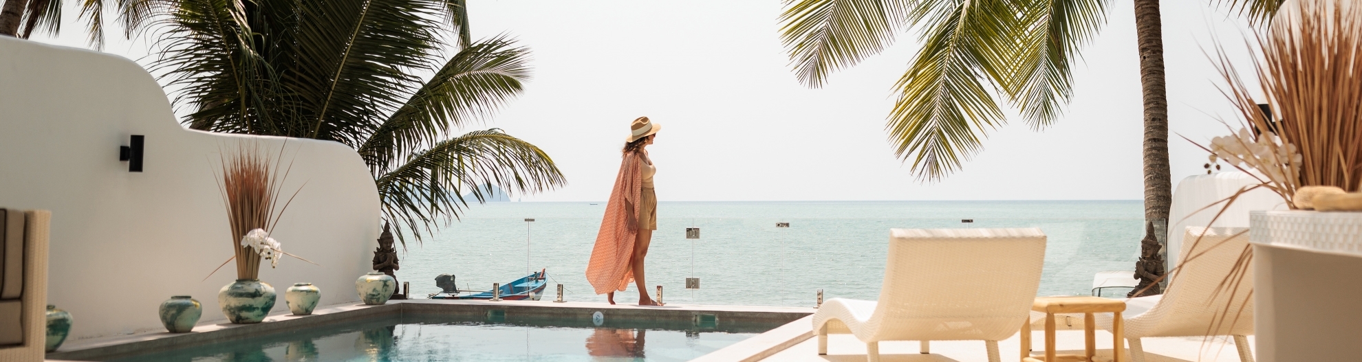 Woman on vacation by pool overlooking the ocean in paradise